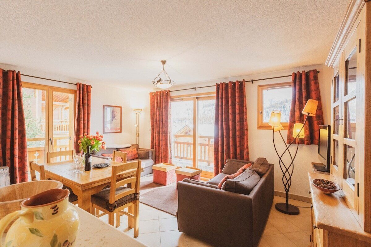 Una sala de estar acogedora con sofá, mesa de comedor, sillas y televisor.