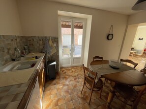 A kitchen with a sink, stove, and dining table.