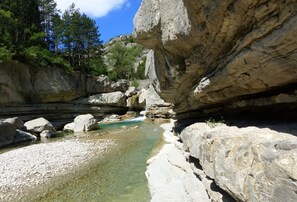 A natural rocky landscape with a clear water stream and surrounding vegetation. - La Maison D'augusta (Val Buëch-Méouge)
