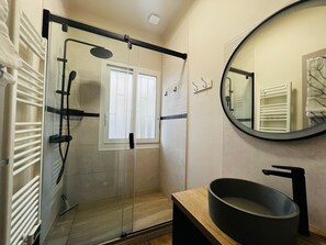 A modern bathroom with a glass shower enclosure, a round mirror, and a black sink. - Argelès Beach House, Parking, 50m from the beach (Argelès-sur-Mer)