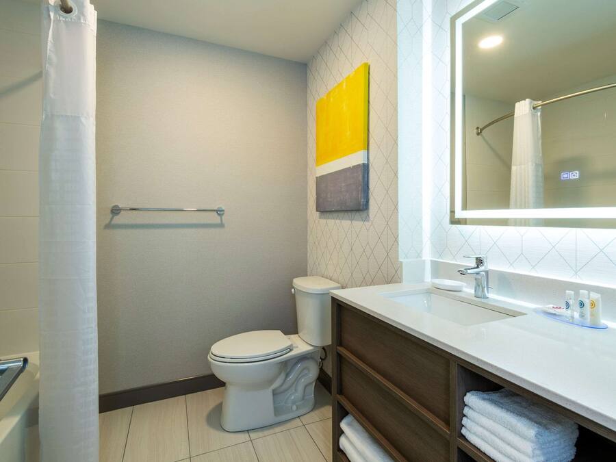 Un baño moderno con inodoro, lavamanos y ducha.