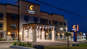 A Comfort Inn & Suites hotel with a modern design, featuring a well-lit entrance and a clear view of the parking area.