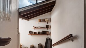 A staircase with wooden beams, shelves with pottery, and barrels on the floor. - Historic 'Casa de Telégrafos' with Mountain Views, Private Terrace & Wi-Fi (vallehermoso)