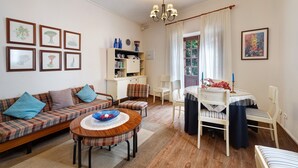 A living room with a sofa, a dining table, and a bookshelf. - Historic 'Casa de Telégrafos' with Mountain Views, Private Terrace & Wi-Fi (vallehermoso)