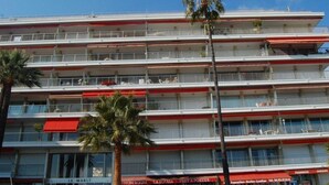 A multi-story hotel with balconies and palm trees. - Spacious Studio with Sea View, Terrace, Near Center and Beaches in Menton (Menton)