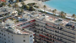 A multi-story hotel with a rooftop pool, located near a beach with palm trees. - Spacious Studio with Sea View, Terrace, Near Center and Beaches in Menton (Menton)