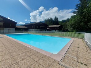 A rectangular swimming pool with a white fence surrounding it. - Family apartment with pools in Samoëns (Samoëns)