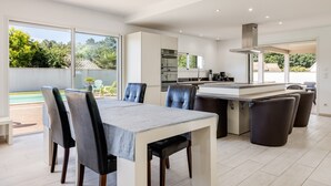 Una cocina moderna con comedor, ventanas amplias y vistas al exterior.
