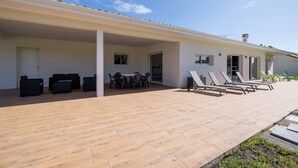 Un espacio al aire libre techado con patio, asientos y vista al cielo.