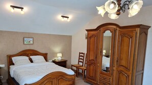 Un dormitorio con una cama de madera, una mesita de noche, una silla y un armario.