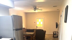 A compact kitchen with a refrigerator, a dining table, and a sofa. - Guest House with pool, boat parking (Leesburg)