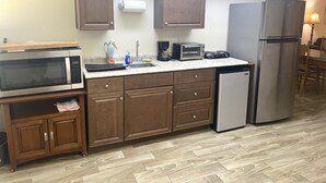 A kitchen with wooden cabinets, a microwave, a toaster, a refrigerator, and a sink. - Guest House with pool, boat parking (Leesburg)