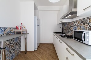 A compact kitchen with a microwave, stove, and refrigerator.