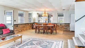 Una sala de estar amplia con comedor, chimenea y escalera.