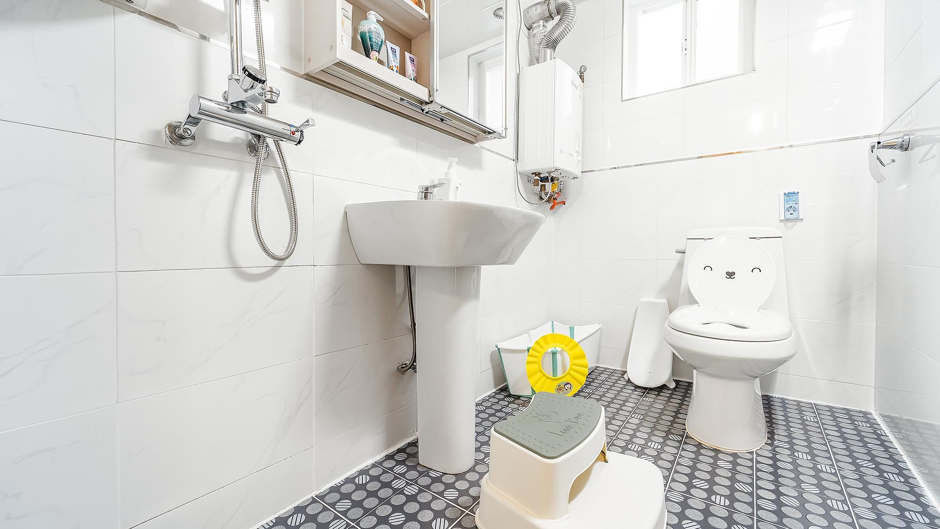 Un baño con inodoro, lavamanos y ducha.