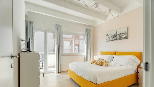 Une chambre à coucher avec un lit, une armoire, un bureau et une fenêtre avec des rideaux.