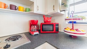 A kitchen with a red coffee maker, a red microwave, and a fruit bowl on the counter. - 🏳️‍🌈 #2:  Walk to Wilton Drive (with kitchen) (fort lauderdale)