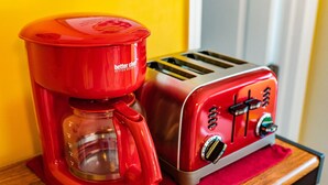A red coffee maker and a toaster on a wooden surface. - 🏳️‍🌈 #3 Walk to Wilton Drive (fort lauderdale)