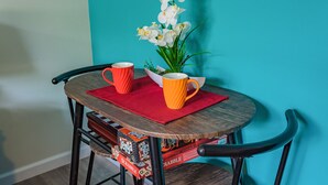 Una mesa con dos tazas, una planta y un libro.