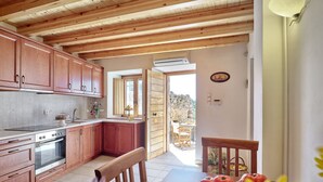 Una cocina con armarios de madera, estufa y comedor con mesa y sillas.