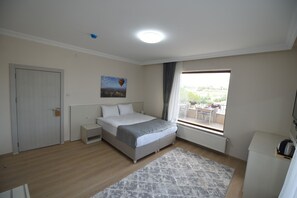 Un dormitorio con cama, mesita de noche, ventana con vistas y radiador.