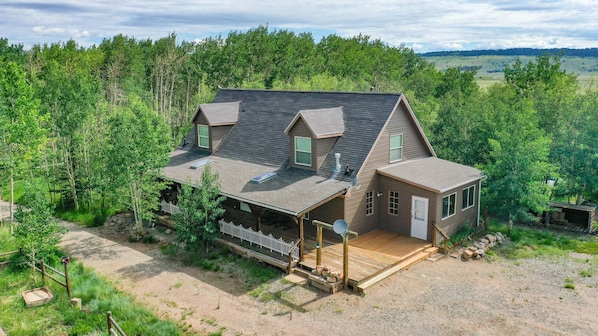 A two-story house with a covered porch, a small detached garage, and a fenced yard.