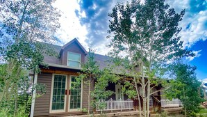 A rustic wooden house with a porch, surrounded by trees and a gravel driveway. - Hot Tub in 39 Acres of Aspens - Mtn Views, 23mi to Breck, Pet-Friendly (Fairplay)