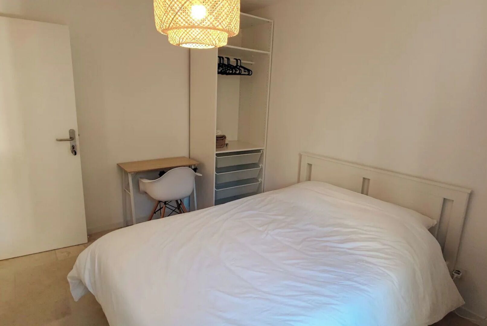 Ein Schlafzimmer mit Bett, Schreibtisch und Kleiderschrank.