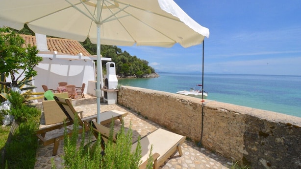 A patio with outdoor furniture, a grill, and a view of the sea. - THE COTTAGE (Nisaki)