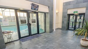 Zona de piscina amb portes de vidre, una piscina i una planta en test.