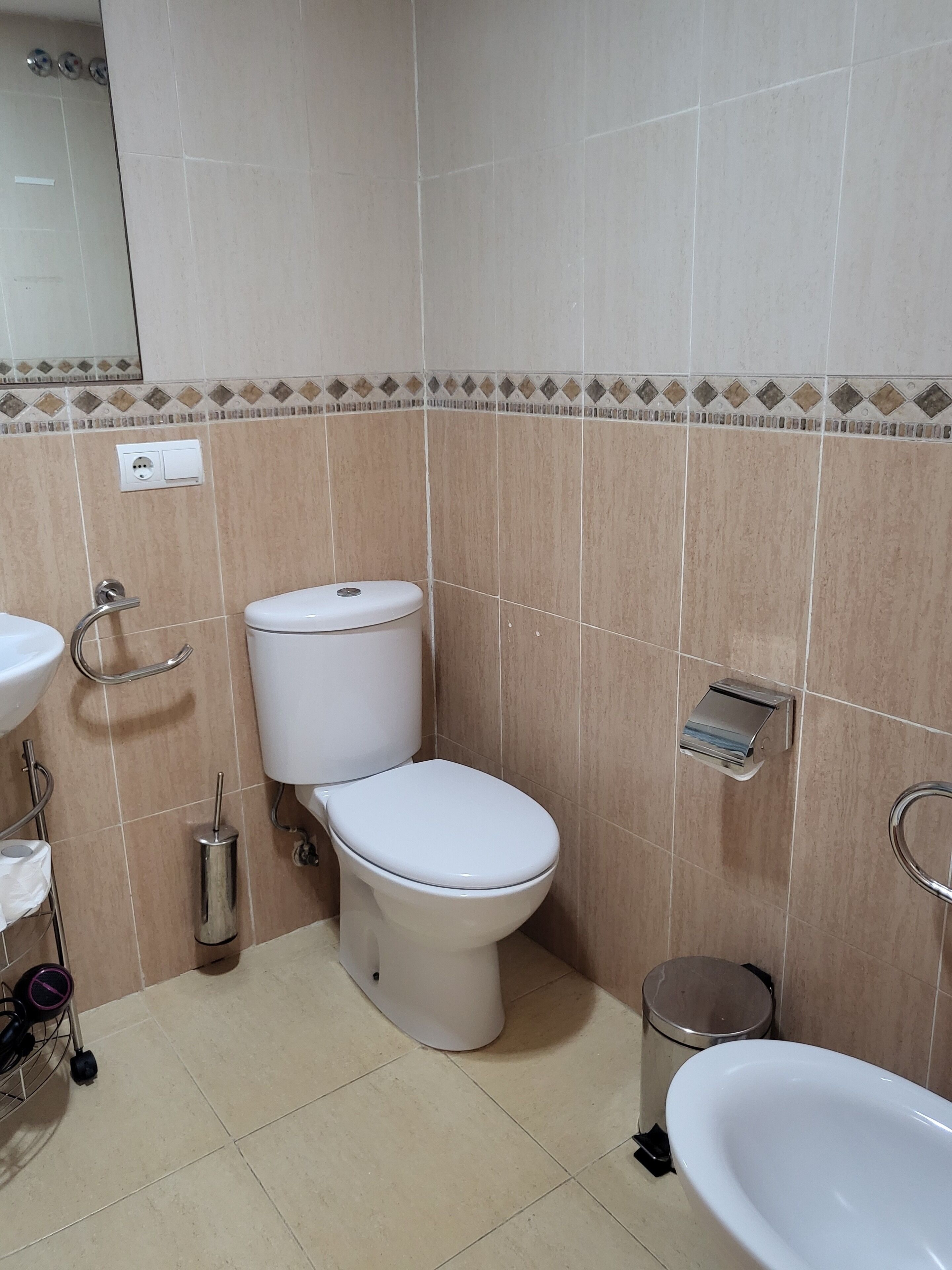 Un baño con inodoro, lavamanos y bidé.