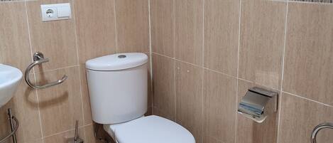 Un baño con inodoro, lavamanos y bidé.
