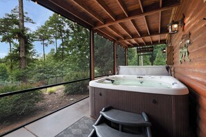 A hot tub in a covered wooden cabin with a view of the forest. - Soaring Hawk Lodge - Morganton, GA (Morganton)