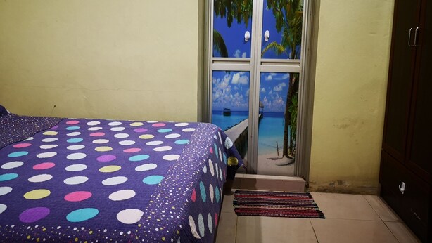 Una camera da letto con un letto, una finestra vista mare e una porta che dà all'esterno.