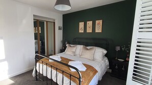 Un dormitorio con cama, mesita de noche, tocador y armario.