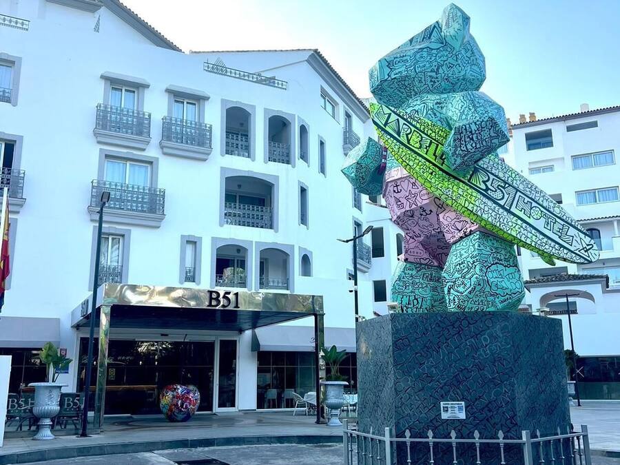 Un hotel con un letrero que dice "B51" y una escultura decorativa en primer plano.
