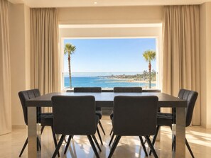 Un espace repas avec vue sur la plage et l’océan.