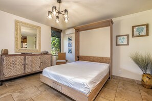 Ein Schlafzimmer mit Himmelbett, einem Holzschrank und einem großen Spiegel.