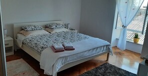 A neatly made bed with floral bedding, a bedside lamp, and a small nightstand.