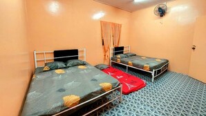 Una habitación con dos camas, ventilador de techo y suelo estampado.