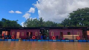Una estructura flotante con varias habitaciones, cada una con puerta y ventanas, y anillos salvavidas adheridos al exterior.