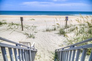 A beach view with a wooden staircase leading down to the sand, a sign that reads "KEEP OFF DUNES," and a clear blue sky. - 7 Bed, 7.5 Bath, Oceanfront Home, Private Pool that can be heated (Garden City Beach)