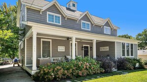 A two-story house with a covered porch, a garage, and a sign that reads "Beach." - You Are My Sunshine (South Haven)