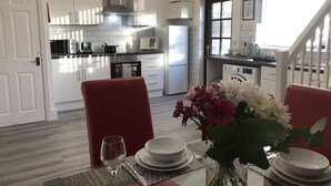 Une cuisine moderne avec des armoires blanches, une hotte de cuisinière en acier inoxydable et un four encastré.