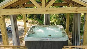 Un gazebo en bois avec un jacuzzi.