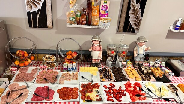 A buffet with various food items and a decorative figure. - El pozo de la Nieve (Tordesillas)