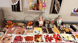 Buffet com diversos alimentos e uma figura decorativa.
