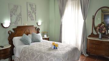 Une chambre à coucher avec un lit en bois, une table de chevet, une commode, un miroir et une fenêtre avec des rideaux.