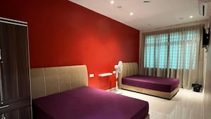 Une chambre d’hôtel avec deux lits, une armoire, un bureau et une fenêtre avec des rideaux.