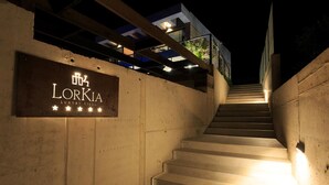 Una escalera conduce a un edificio con un letrero que dice "LORKIA LUXURY VILLA".